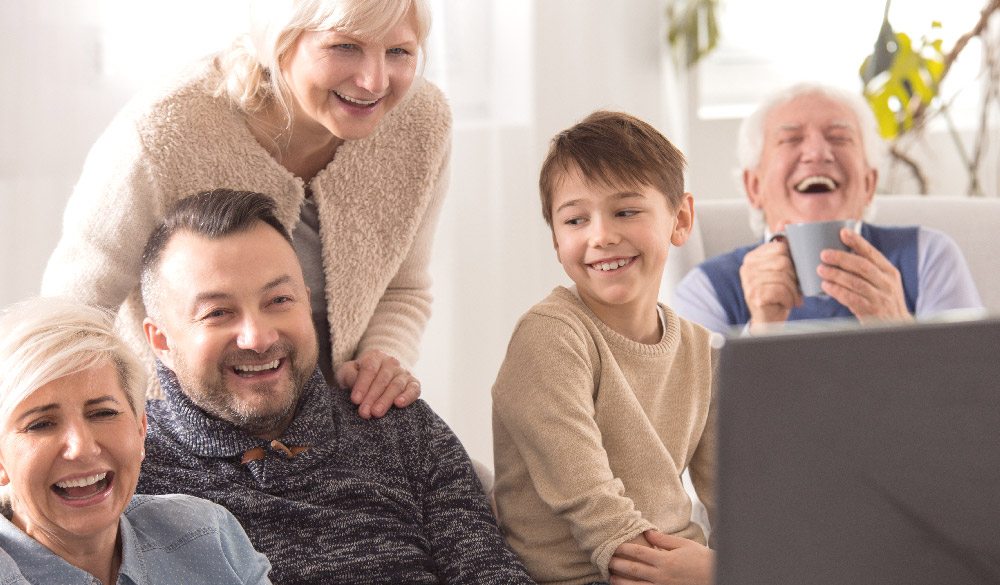 Intergenerational family watching tv and laughing