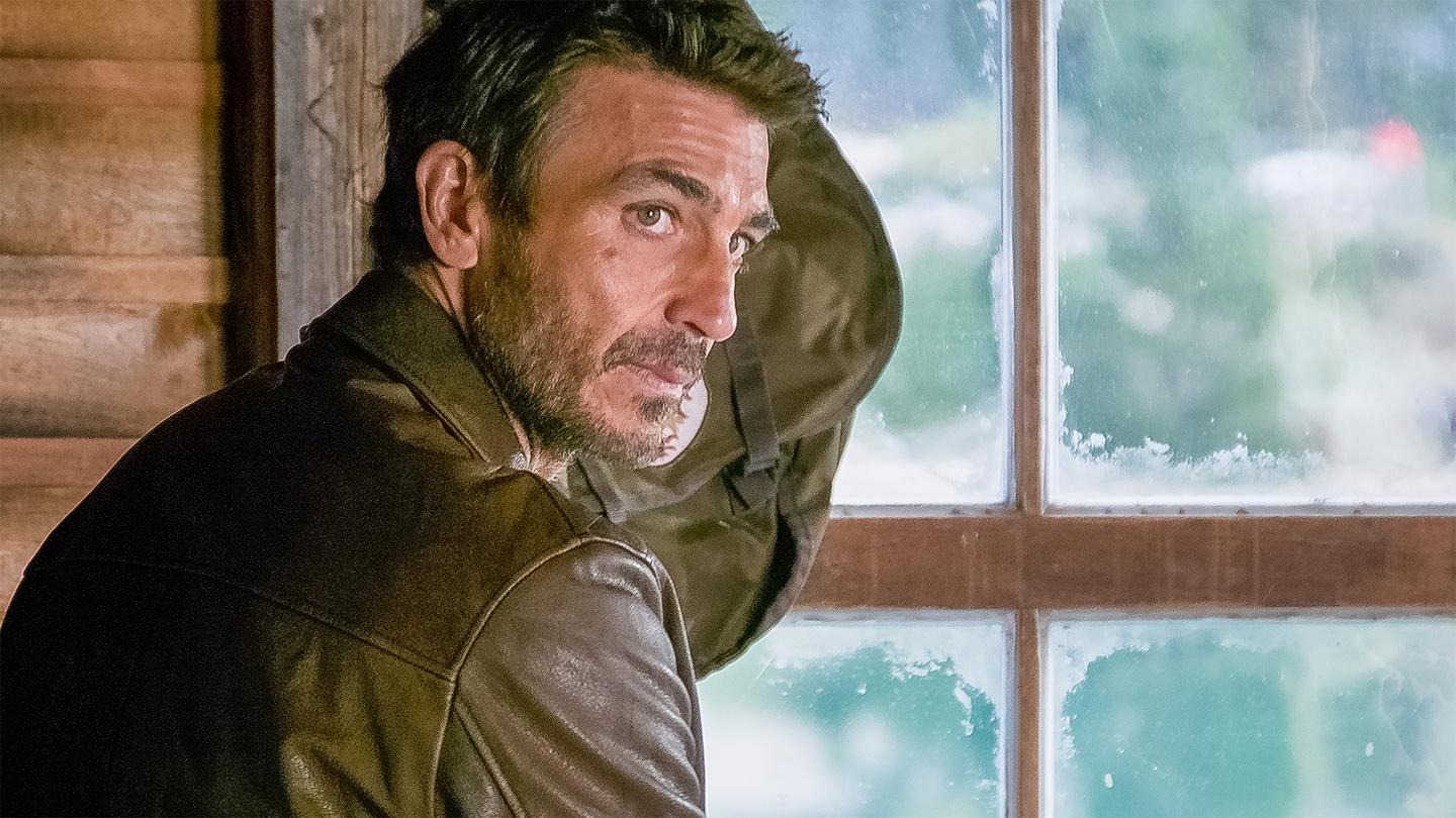 a man standing next to a window