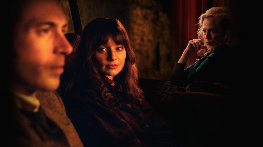three adults in a dimly lit background